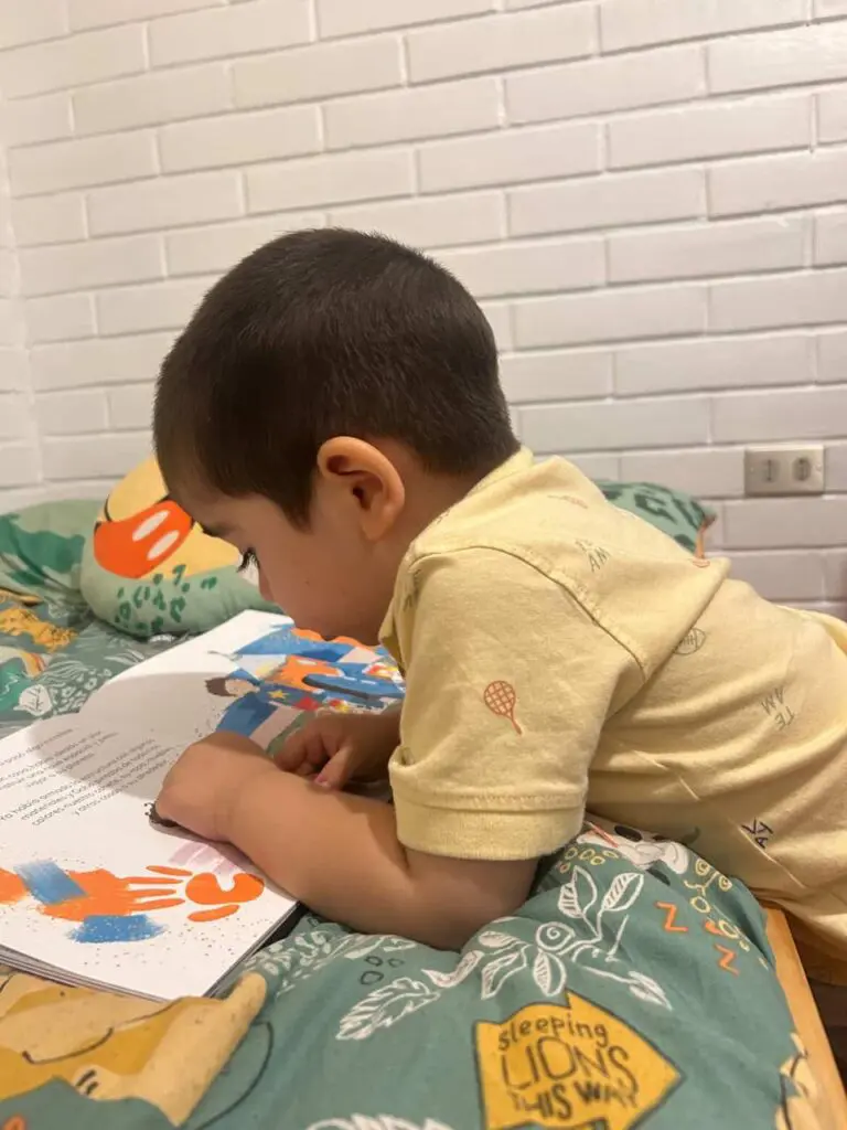 Niño leyendo sobre su cama libro playfunlearn