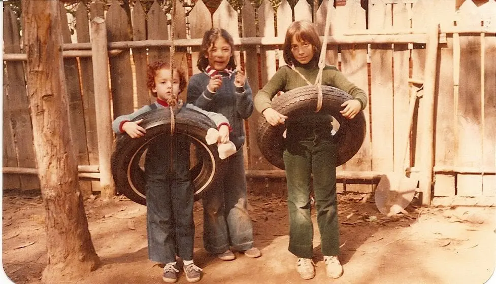 3 niñas jugando con columpios antiguos