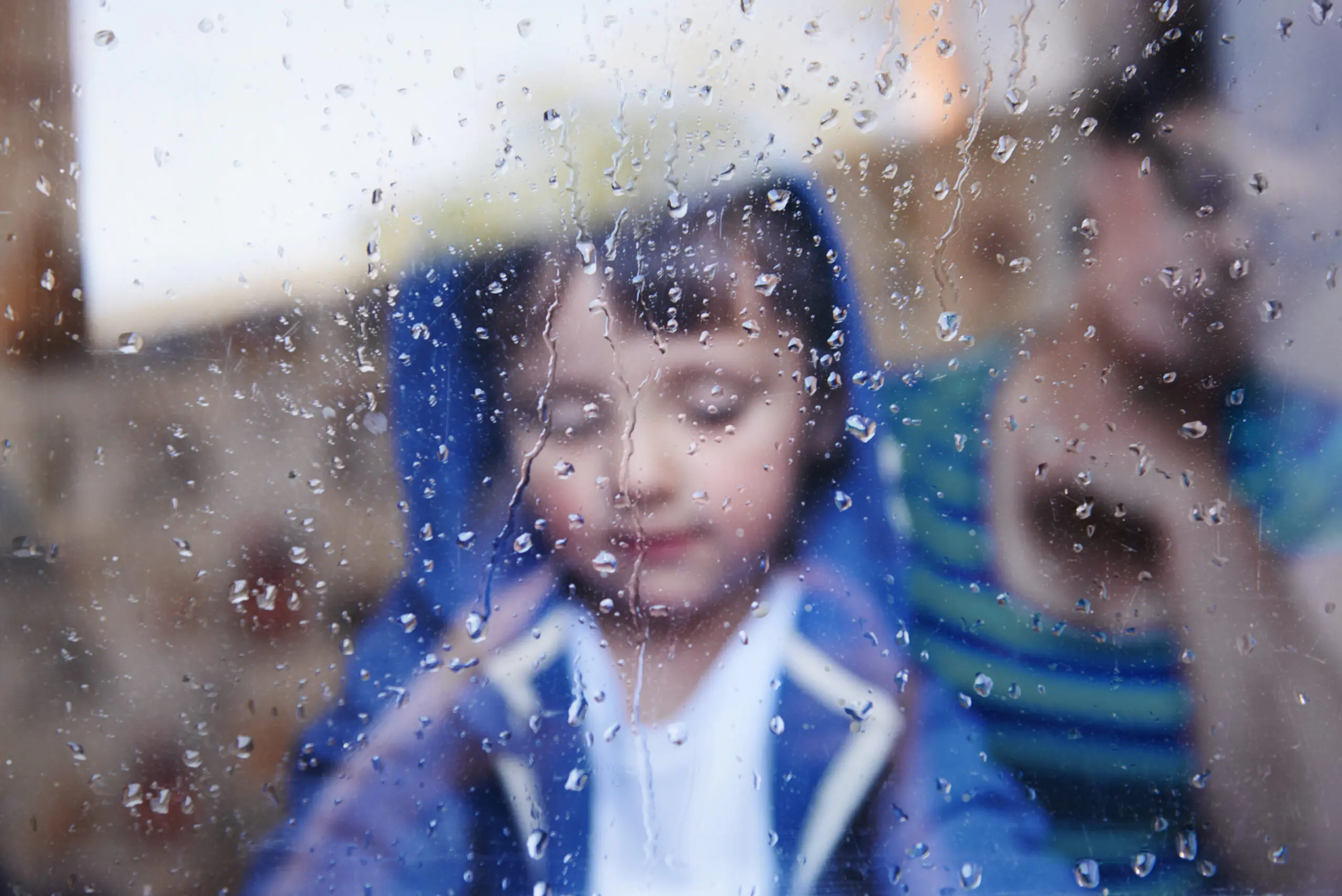 Niño ve la lluvia sin nada que hacer